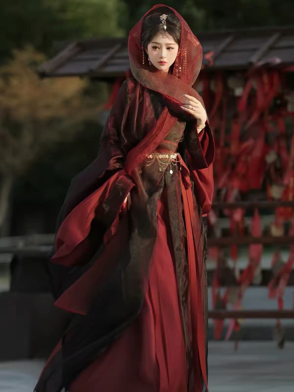 Styled view of Yu Ji Tan burgundy and black hanfu showing the cross collar, sleeve details and draped fabric.